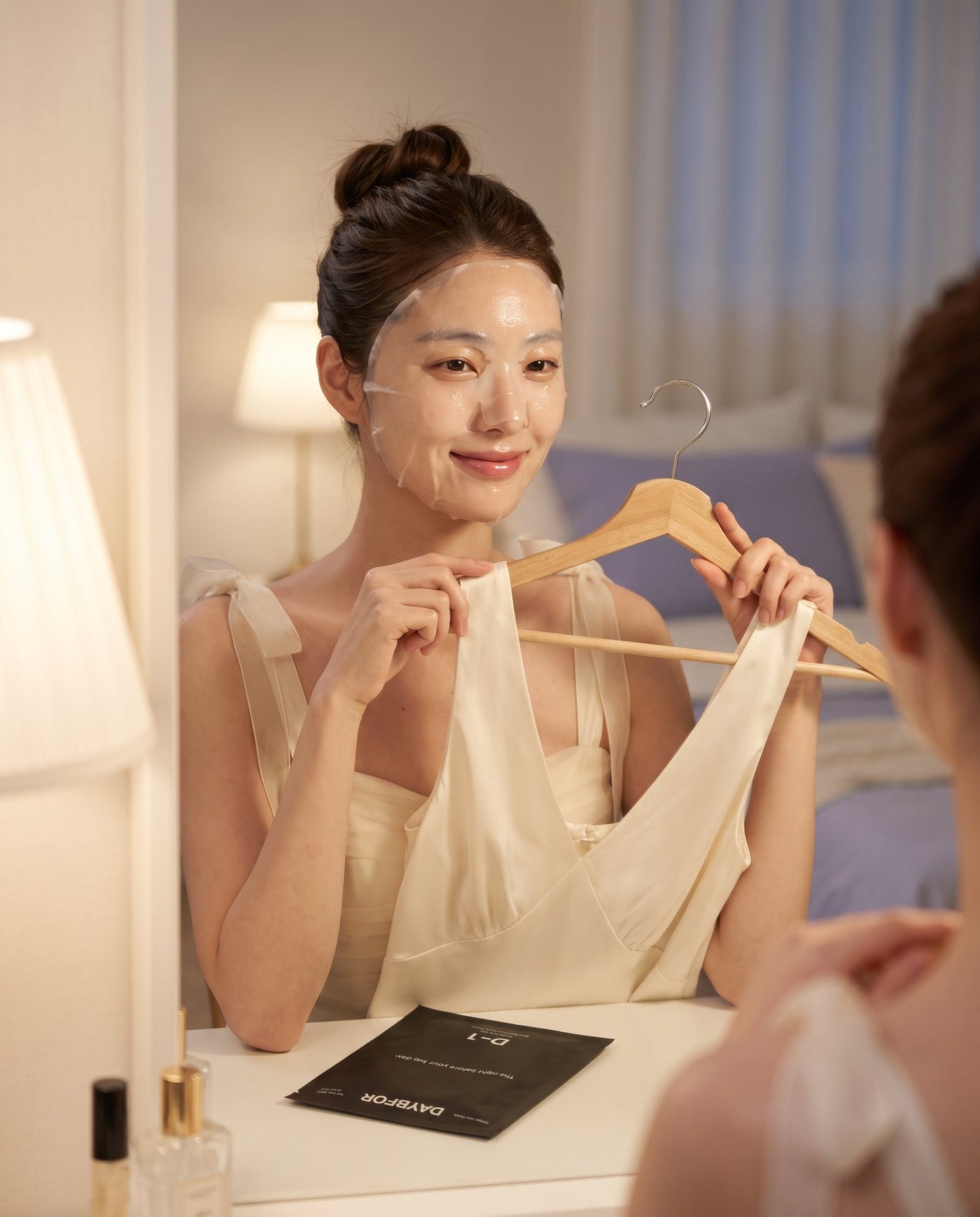 A woman wearing a DAYBFOR D-1 sheet mask the night before a big day, holding up her dress
