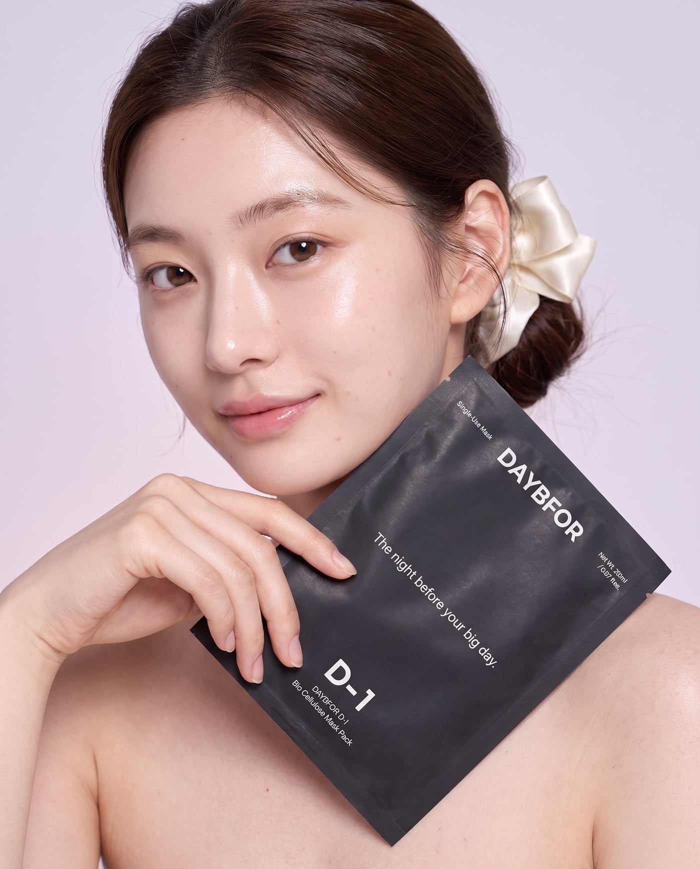 A woman holding the DAYBFOR D-1 Bio Cellulose Mask Pack pouch